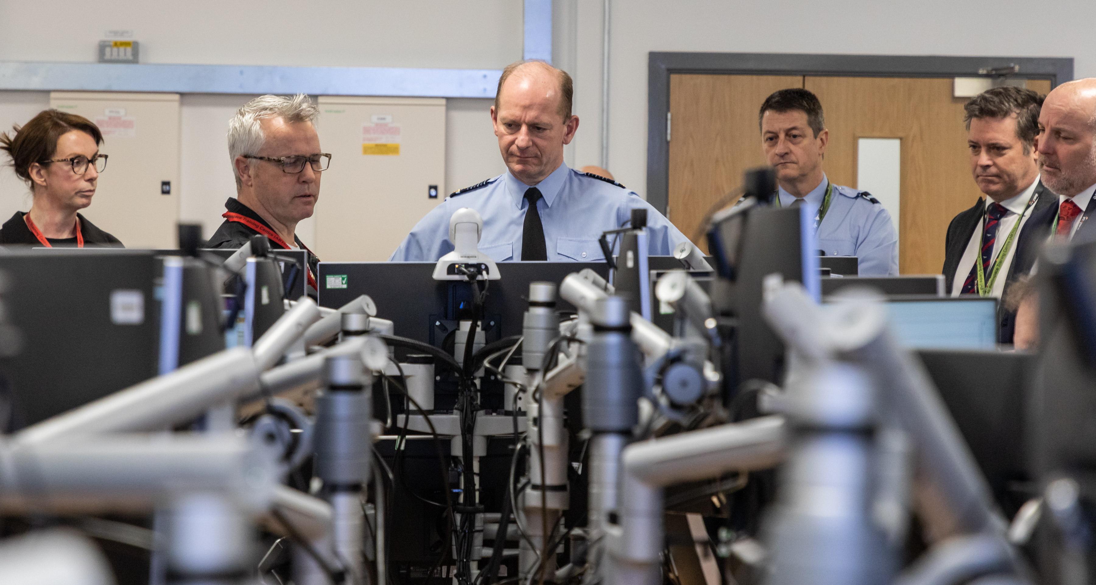 Image shows the Chief of the Air Staff with RAF aviators and civilians looking at desktop computers.